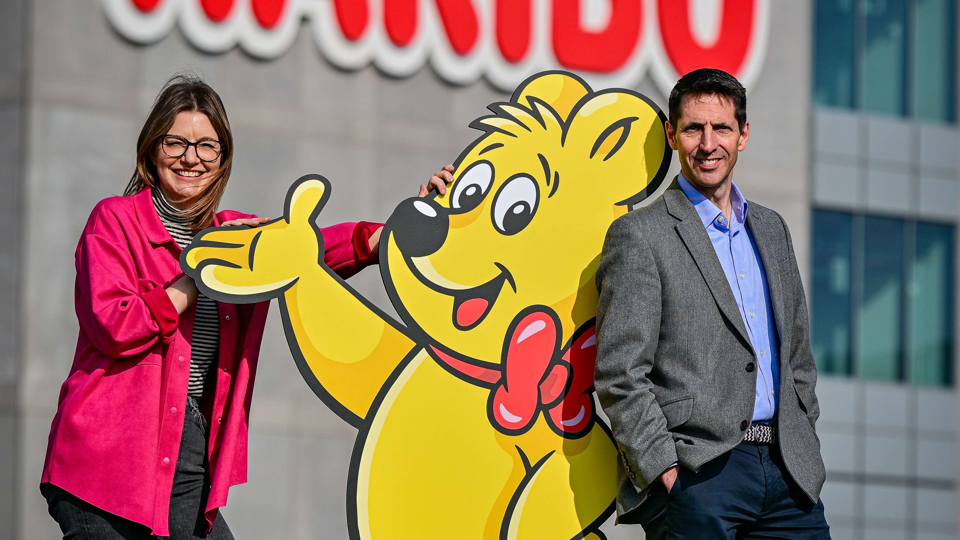 HARIBO UK Managing Director Jon Hughes and Louise Goulden CEO and founder of The Together Project pose with HARIBO Goldbear infront of the HARIBO factory.
