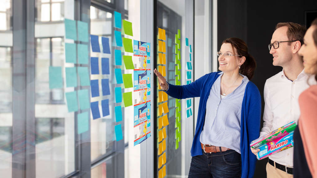 HARIBO-Mitarbeiterin vor einer Wand mit bunten Post-its