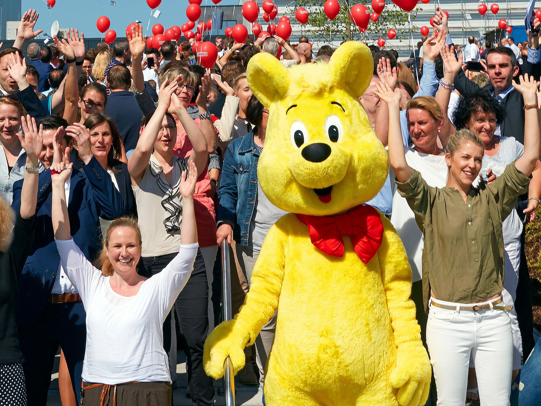 Munkatárs és életnagyságú Goldbär a vállalat központja előtt