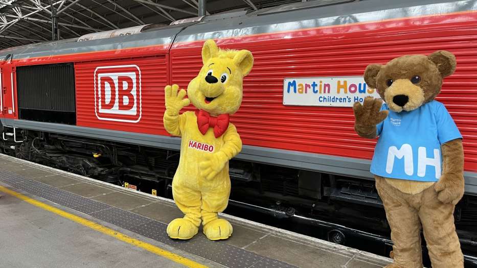 HARIBO Goldbear and Marty Bear mascots show off a custom Martin House train carriage.