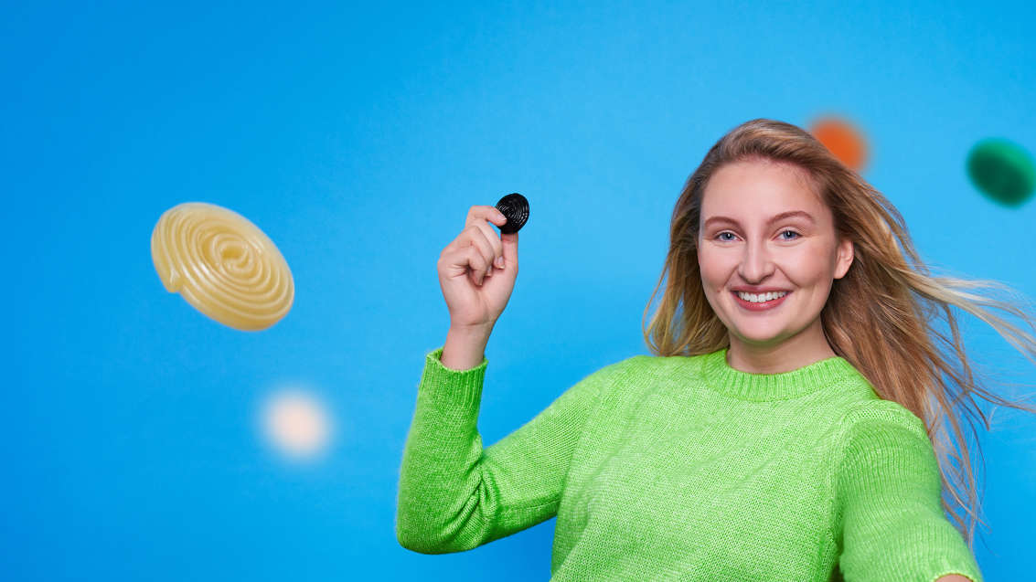 Auszubildende mit Lakritzschnecke in der Hand.