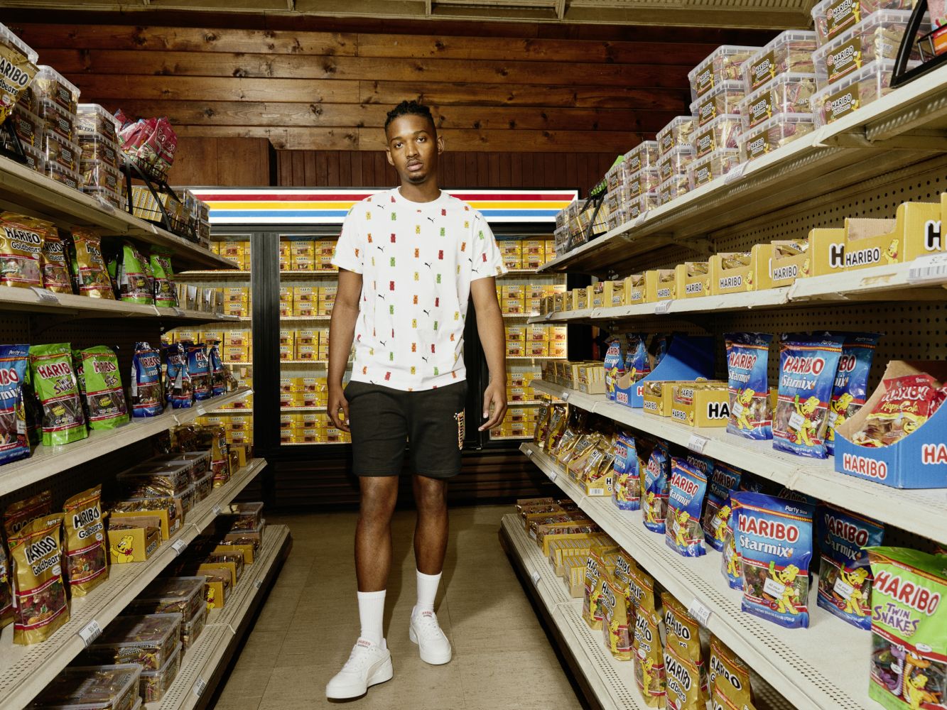 Model steht im Süßwarenregal und trägt PUMA x HARIBO Kollektion.