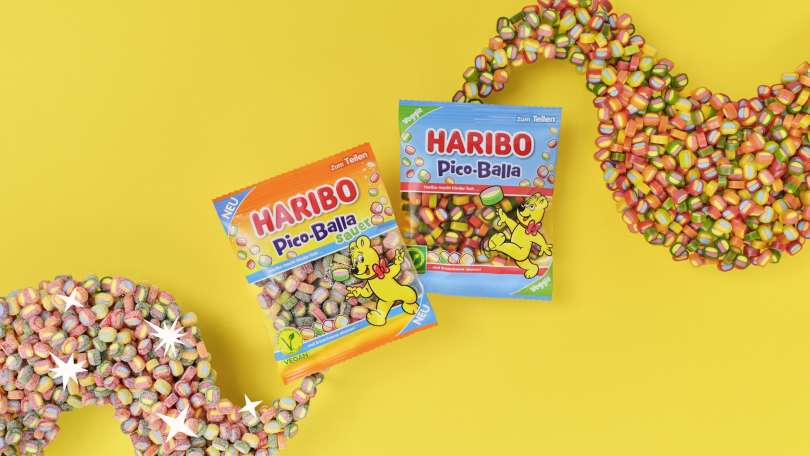 Ein Beutel HARIBO Pico-Balla und ein Beutel HARIBO Pico-Balla Sauer auf gelbem Hintergrund.
