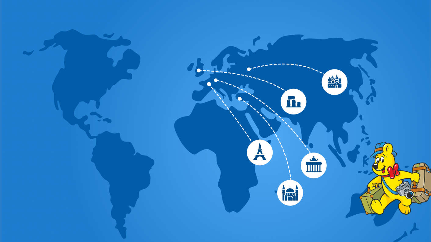 Goldbear with travel suitcases on a map showing well known sights: eifel tower, berlin gate, jesus statue brazil