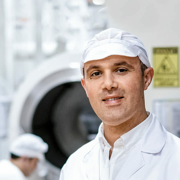 Employee standing in front of production line.