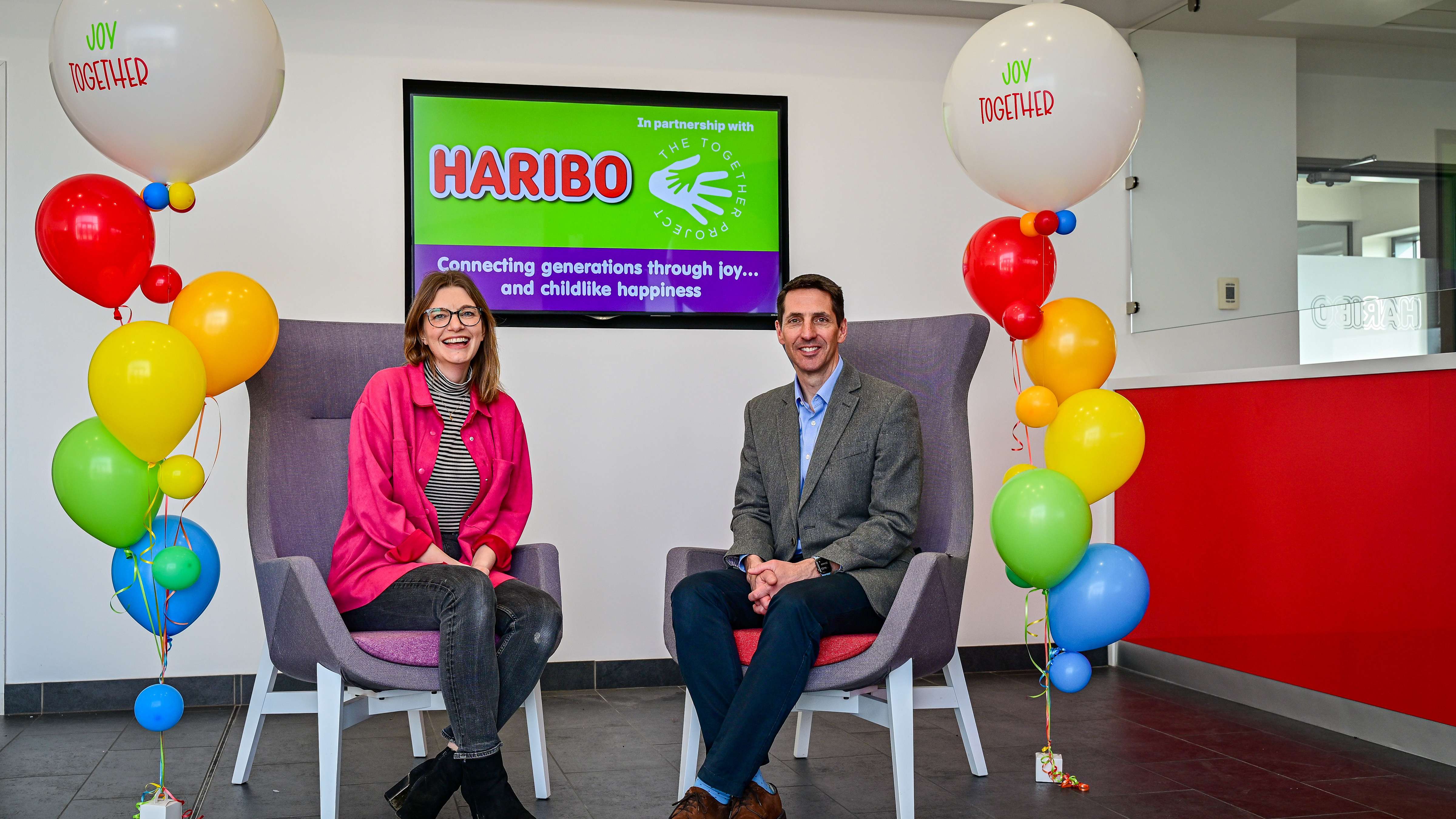HARIBO UK Managing Director Jon Hughes and Louise Goulden CEO and founder of The Together Project sit down in front of branded balloons.