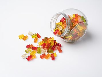 HARIBO Goldbären in einem Bonbonglas vor weißem Hintergrund