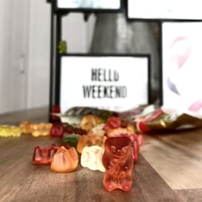 Kúsky Goldbären pred tabuľou s nápisom „Hello Weekend“