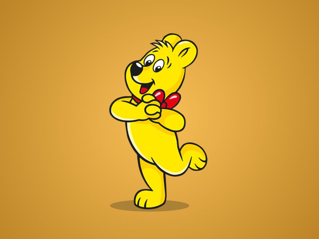 Goldbear dances in front of a golden background