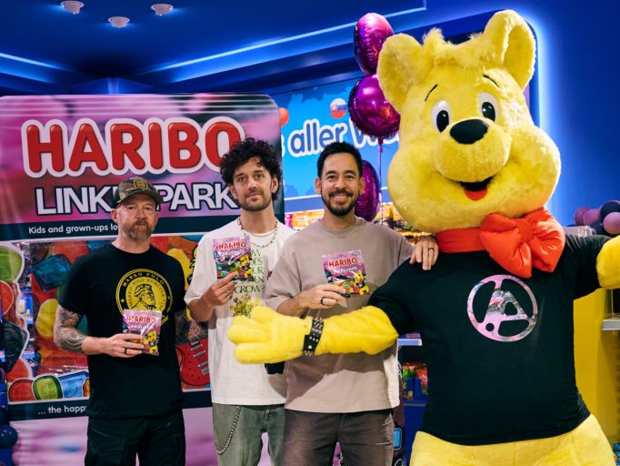Drei Mitglieder der Band Linkin Park zusammen mit dem gelben HARIBO-Goldbären und ihrer Fruchtgummi-Sonderedition im HARIBO Shop Berlin.