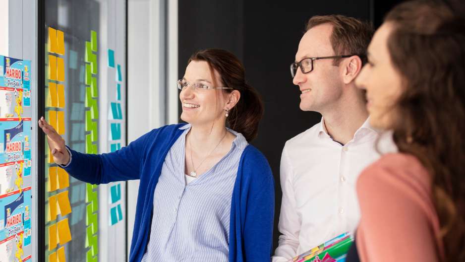 Colaboradores HARIBO e parede com post-its coloridos