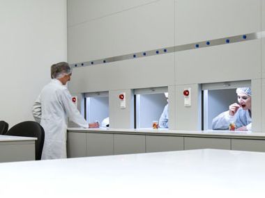 Drei Personen sitzen in Testkabinen im HARIBO-Sensorikraum und testen Produkte