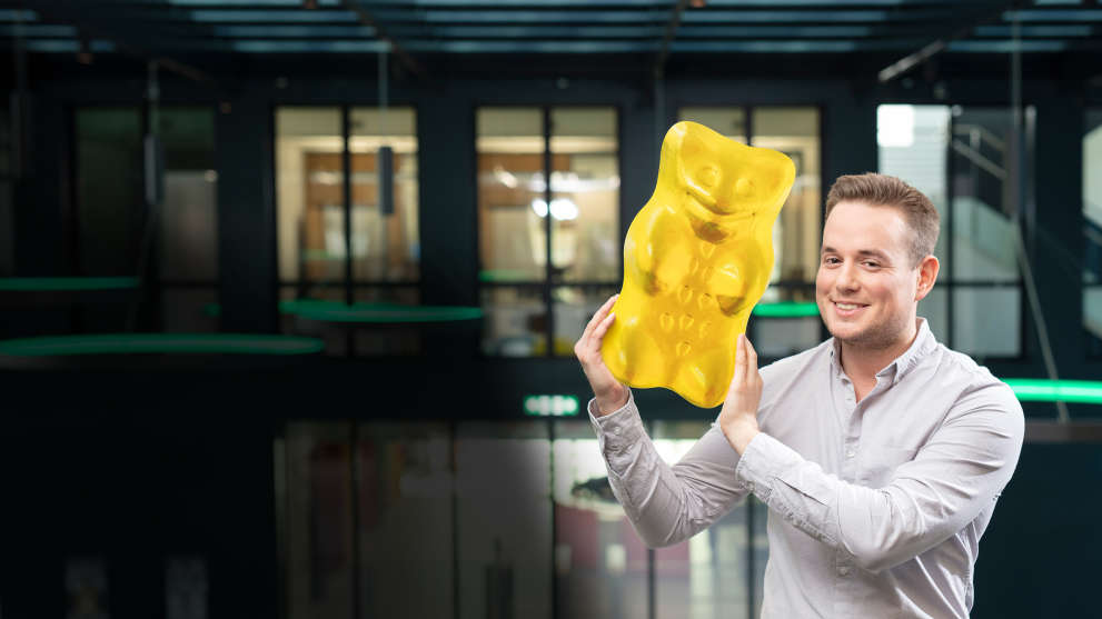 employee holding big yellow gummi bear