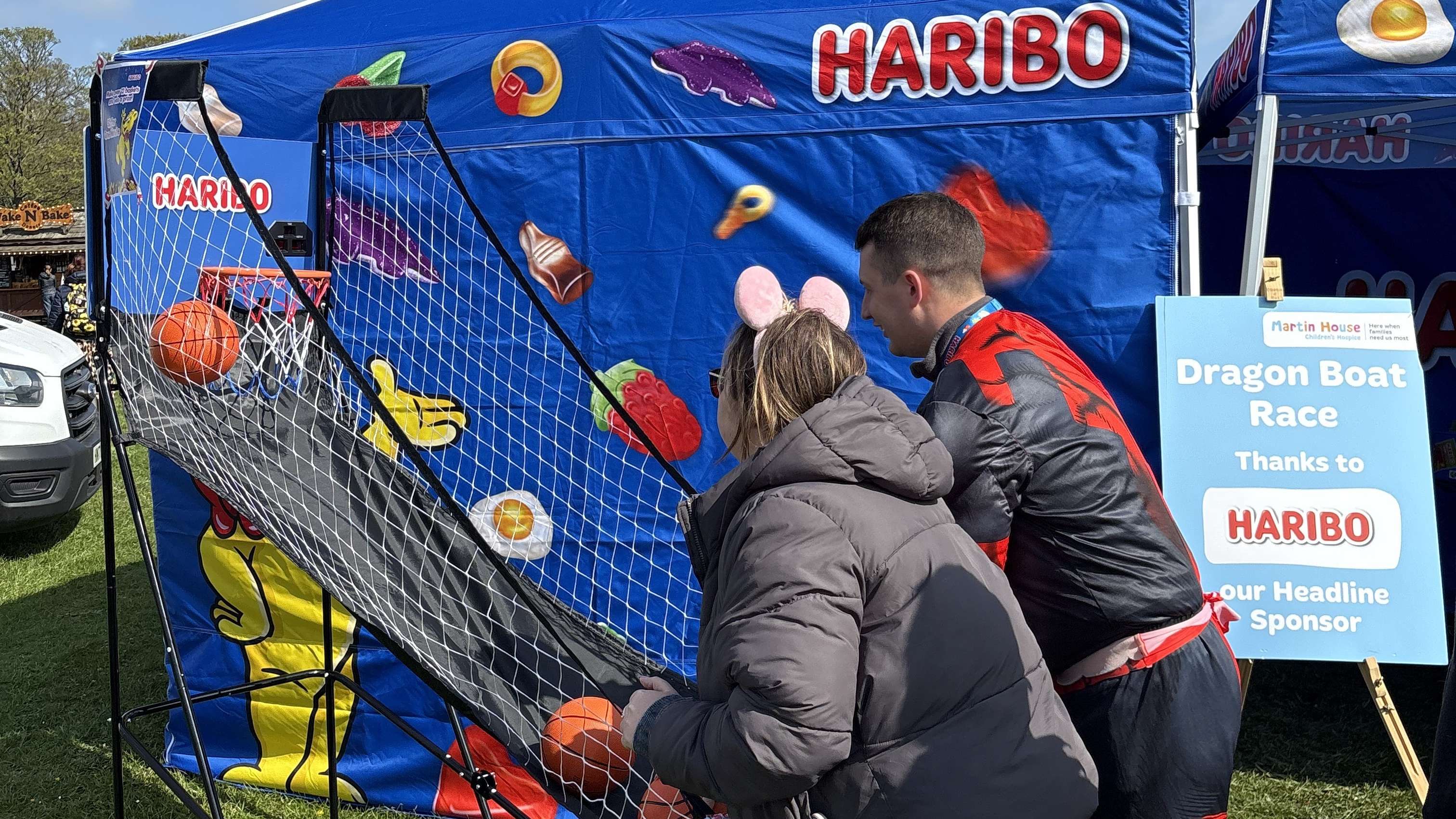 Spectators play a basketball challenge game at the HARIBO stall, fundraising for Martin House