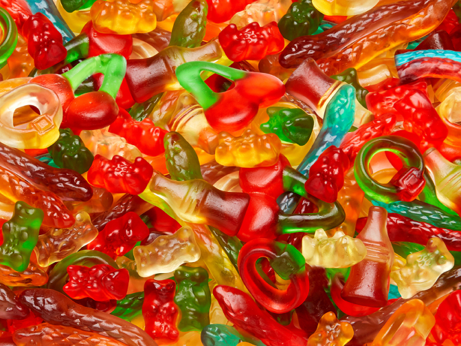 A vibrant close-up of a colorful mix of HARIBO sweets. The text 'Selection of sweets' is displayed in large yellow letters on a blue background, with the subtitle 'This is how it gets colorful and delicious.' This enticing assortment showcases the perfect candy for candy tables – from red candy for candy buffet to gold candy for candy buffet – and helps answer the question of how much candy for a candy buffet when selecting the right variety of sweets for your candy bar ideas setup.