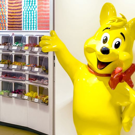 Lebensgroße Goldbär-Figur steht vor der Candy Bar