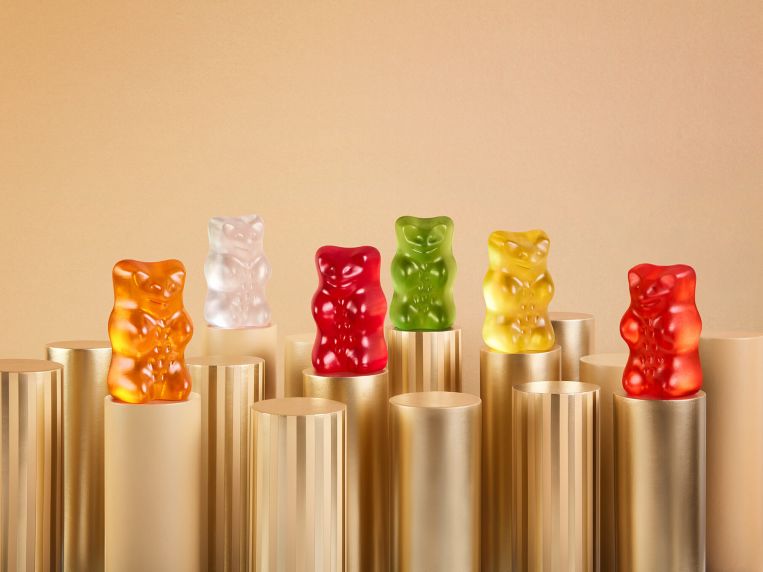 Sechs HARIBO Goldbären stehen auf goldenen Säulen