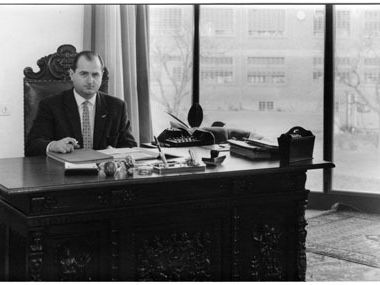 Dr. Hans Riegel sitzt hinter einem Schreibtisch 1950er Jahre in schwarz-weiß