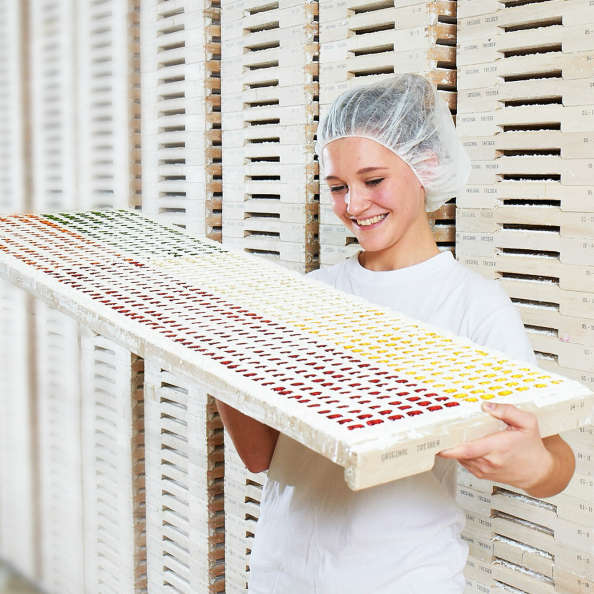 Une collaboratrice inspecte des bonbons gélifiés