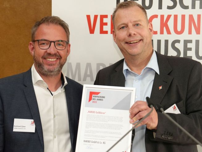 Zwei Männer zeigen eine Auszeichnung des Deutschen Verpackungs Museums