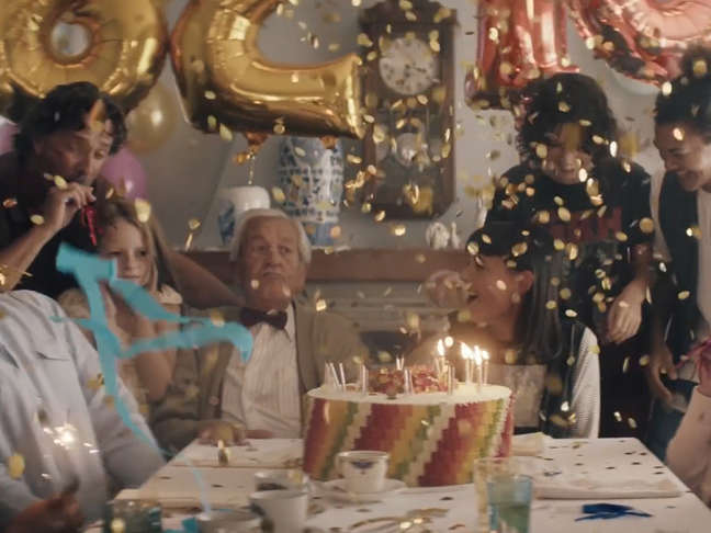 Un groupe de personnes de tous âges autour d’un gâteau Ours d’or