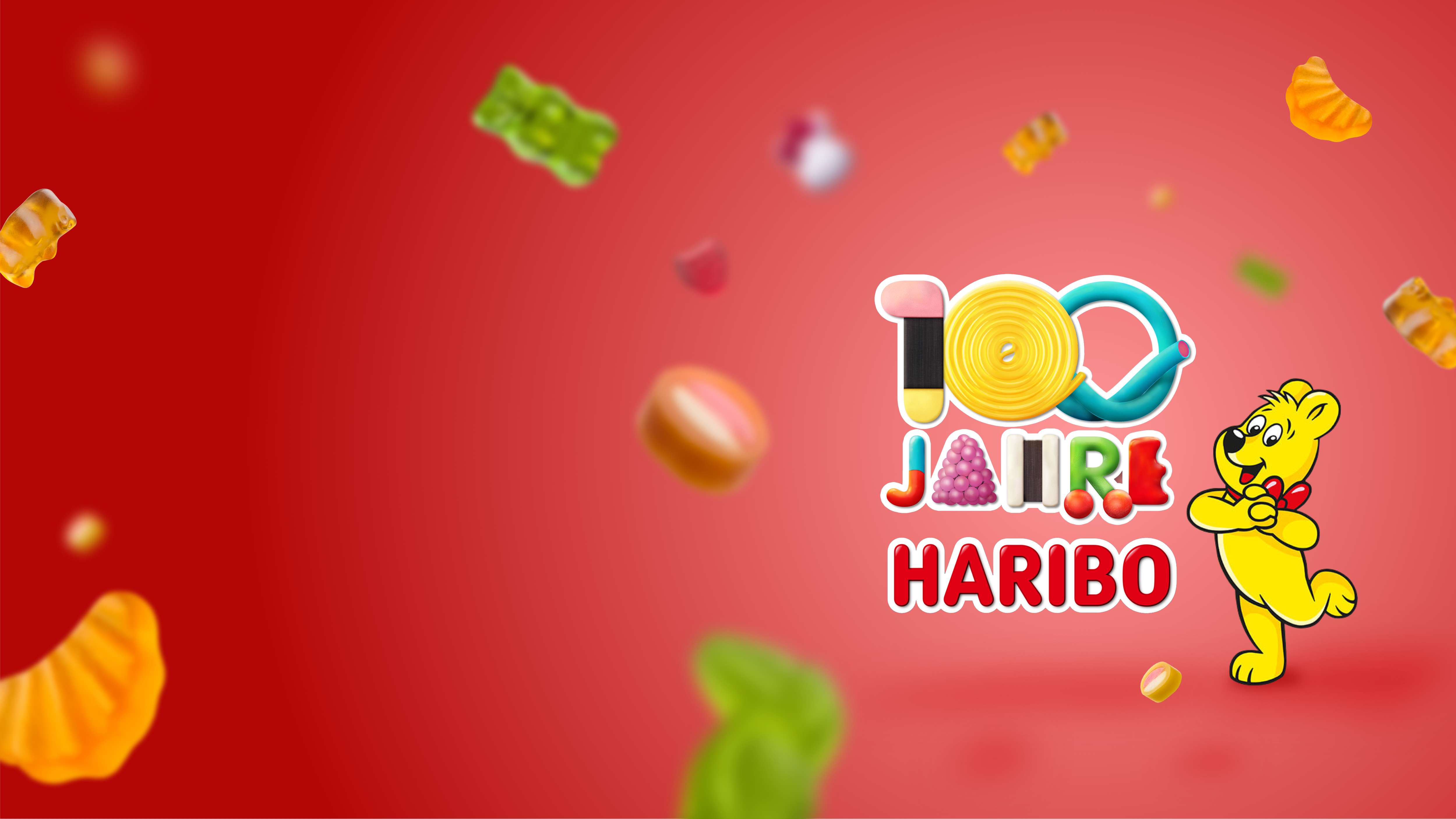 Logo 100 Jahre HARIBO mit Goldbär und rotem Hintergrund mit herumfliegenden HARIBO Produkten.