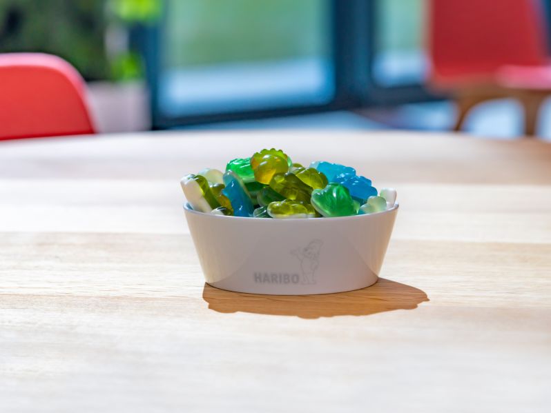 Colourful HARIBO product pieces lying in a bowl on a table