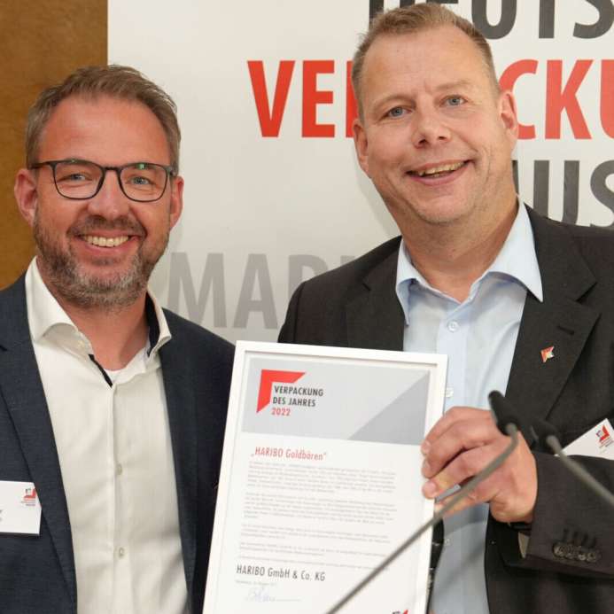 Zwei Männer zeigen eine Auszeichnung des Deutschen Verpackungs Museums