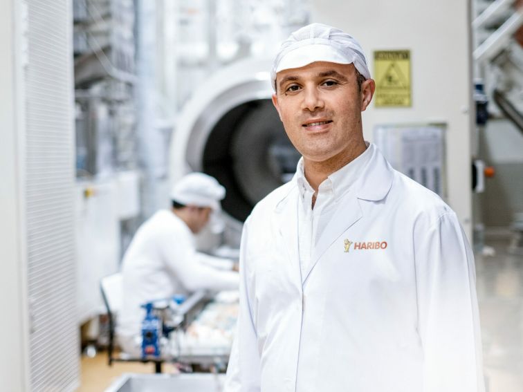 Employee standing in front of production line