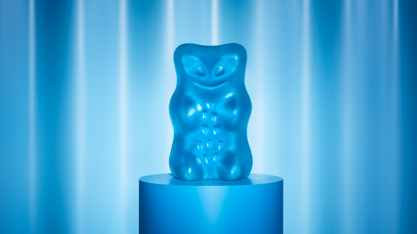 Blauer Goldbär steht auf blauem Podest vor blauem Hintergrund