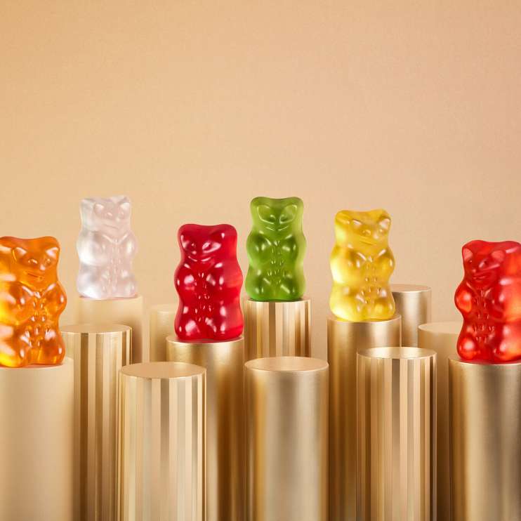 HARIBO Goldbären in sechs Farben stehen auf goldenen Säulen