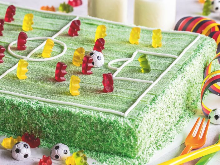 Fußball-Kuchen mit Feld aus grünen Pasta Frutta und Goldbären-Spielern