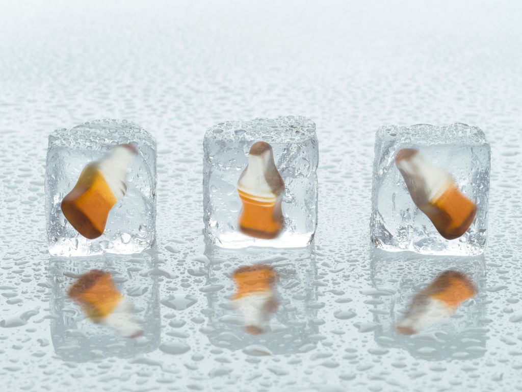 Three Happy Cola bottles in ice cubes