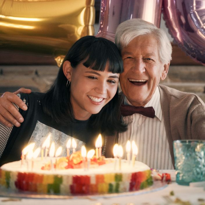 Un grand-père et sa petite-fille devant un gâteau d'anniversaire en ours d'or HARIBO