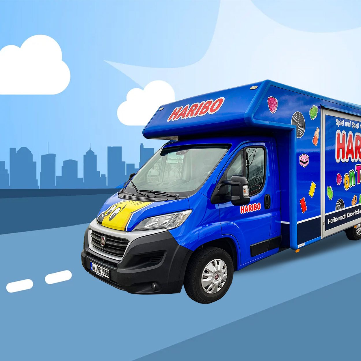 Blaues HARIBO Roadshow-Mobil fährt auf einer Straße