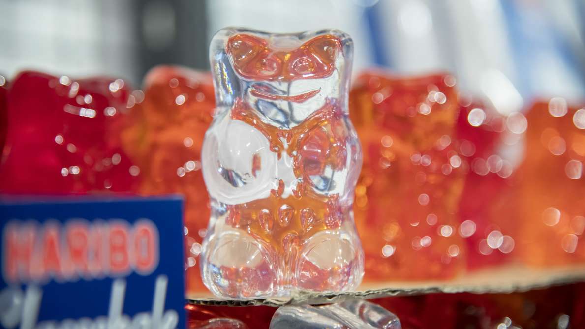 Weißer Deko HARIBO Goldbär mit roten Goldbären im Hintergrund aus dem HARIBO Fabrikverkauf